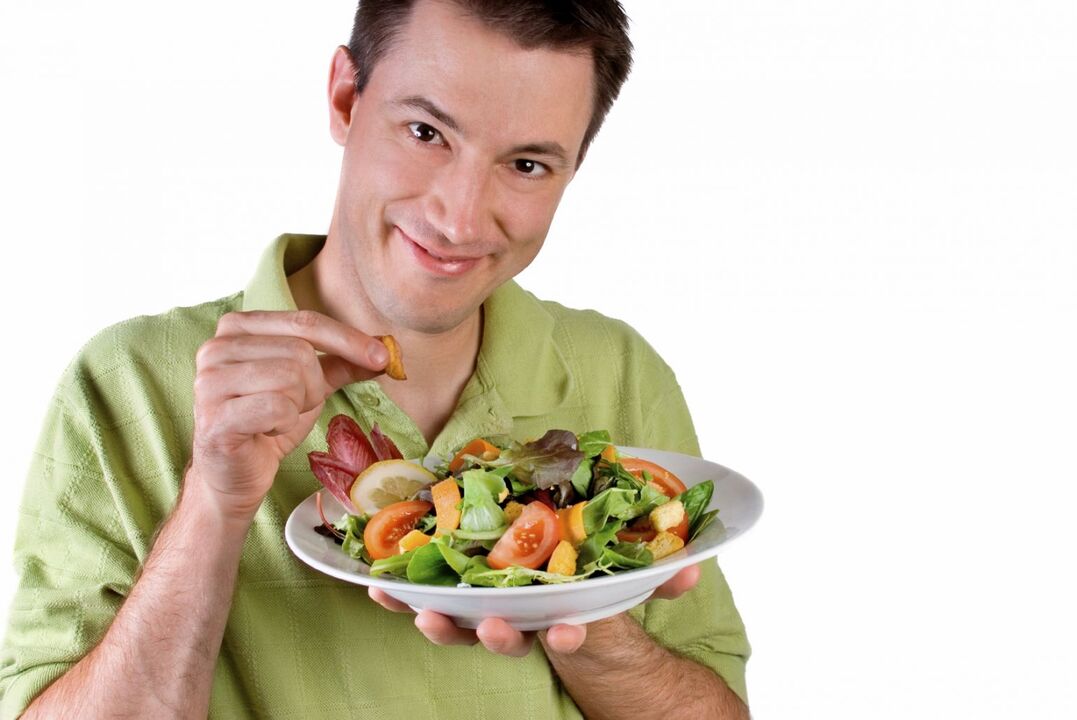 uomo che mangia insalata di verdure per potenza